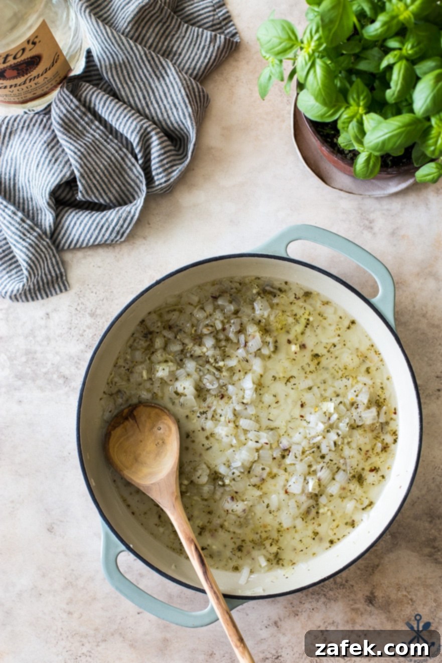 Pink Sauce Penne 6 Overhead photo of a round baking dish containing the sautéed onion and garlic mixture, now deglazed with a generous pour of vodka