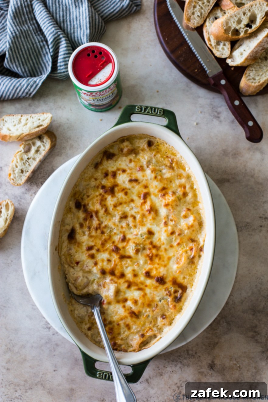 Creole Shrimp Kick 6 Overhead photo of Cajun Shrimp Dip in an oval baking dish, fresh out of the oven, with melted cheese and a golden crust.