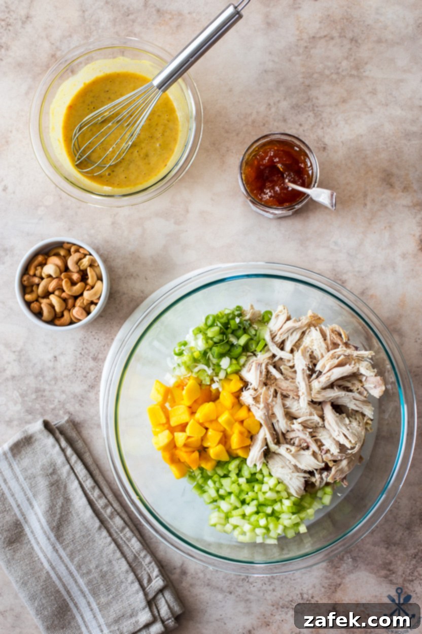 Overhead photo of a bowl with all the curried chicken salad ingredients pre-mixed before adding cashews