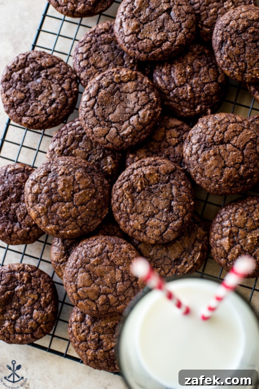 Decadent Fudgy Brownie Cookies 3 Overhead photo of brownie cookies on a wire rack with a glass of milk with two straws