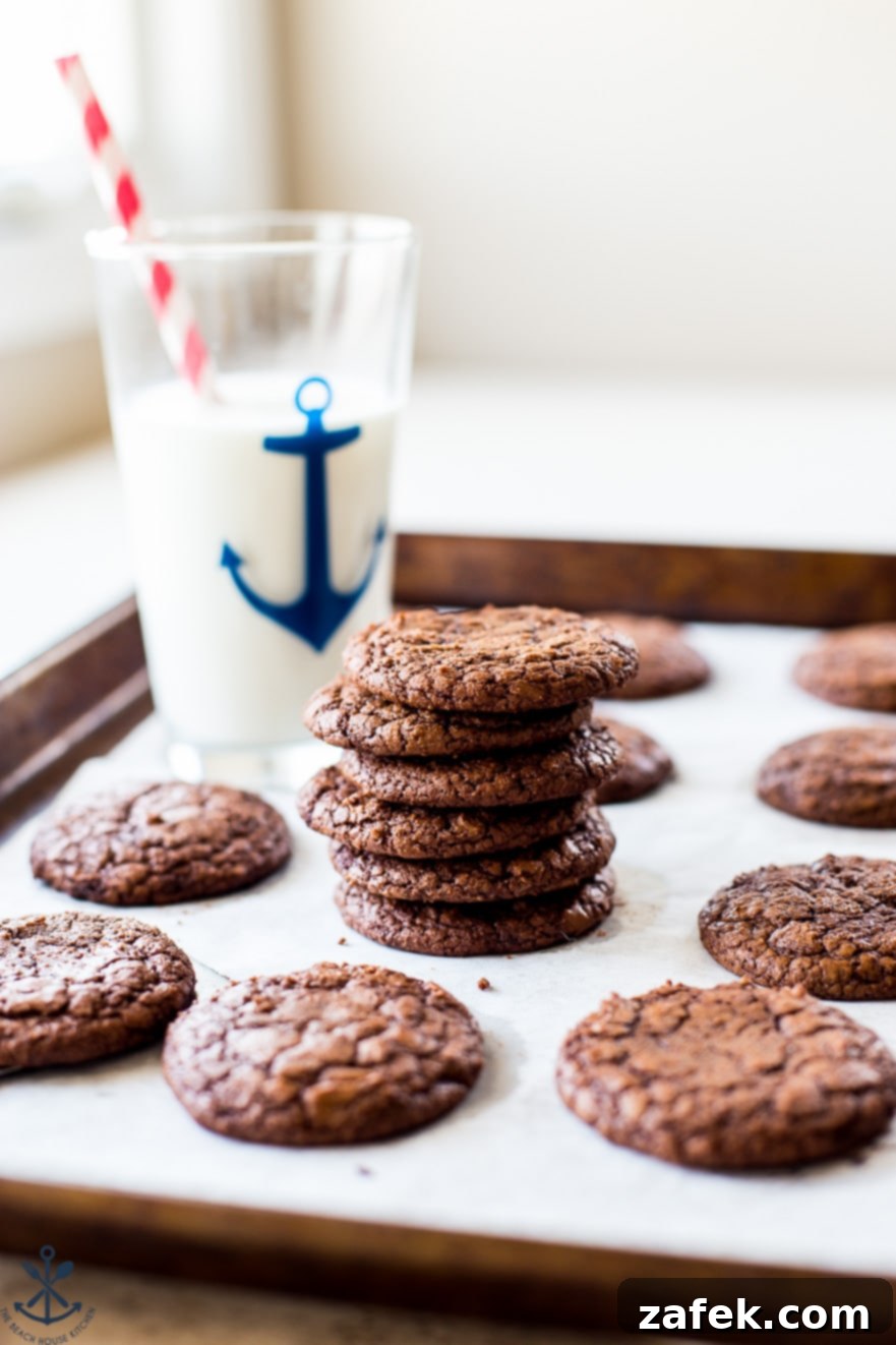 Decadent Fudgy Brownie Cookies 6 A stack of brownie cookies with a tall glass of milk behind it