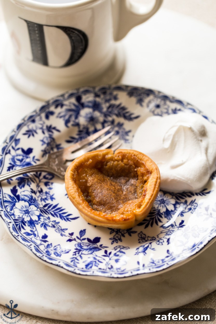 A Canadian butter tart on a blue a white plate with a fork