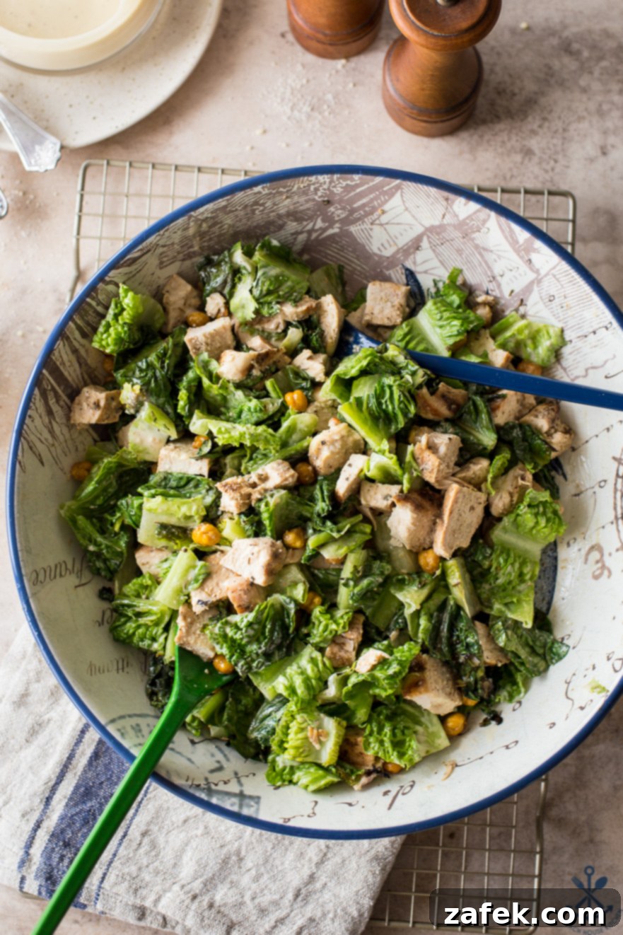 Chargrilled Chicken Caesar with Roasted Chickpea Crunch 2 A vibrant Grilled Chicken Caesar Salad with crispy roasted chickpeas, tender grilled chicken, and smoky grilled romaine, drizzled with creamy Caesar dressing, served in a rustic bowl next to elegant salt and pepper shakers.