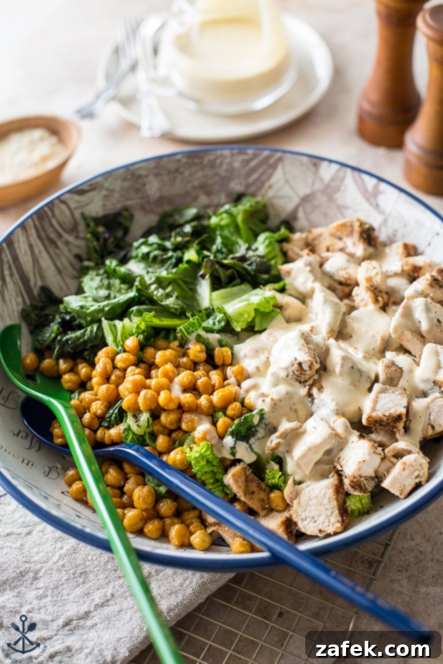 Chargrilled Chicken Caesar with Roasted Chickpea Crunch 3 Close-up of a generous bowl of Grilled Chicken Caesar Salad, showcasing crisp romaine, perfectly roasted chickpeas, succulent grilled chicken pieces, all generously coated in a rich, creamy Caesar dressing.