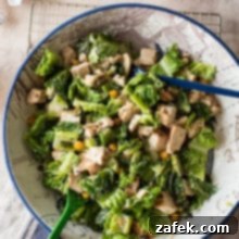 Chargrilled Chicken Caesar with Roasted Chickpea Crunch 8 Overhead photo of a ceasar salad with chikcne and chick peas in a bowl with caesar dressing and wooden salt and pepper shakers off to the side