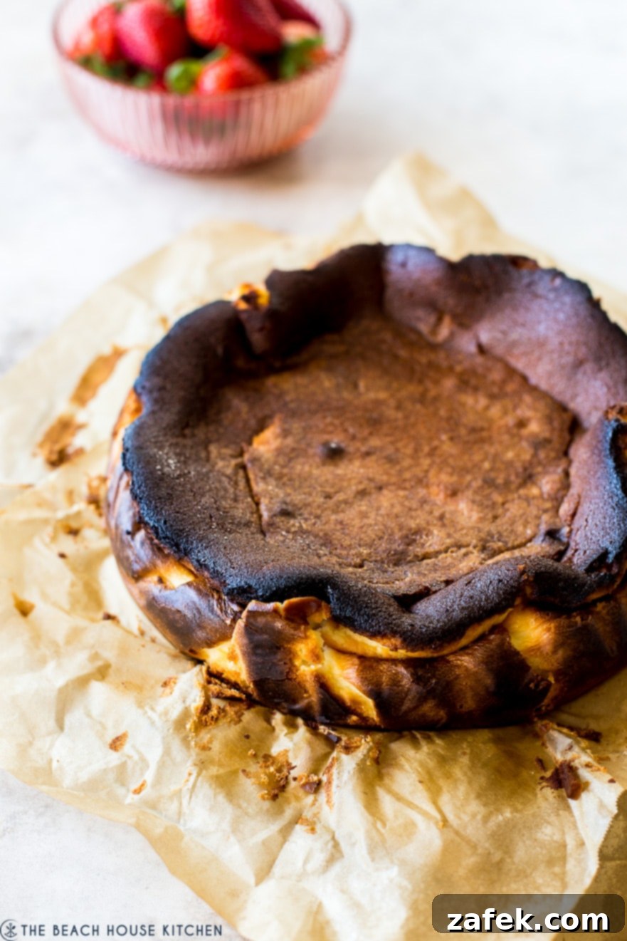 San Sebastian Burnt Cheesecake 3 A burnt basque cheesecake with a bowl of strawberries in the background