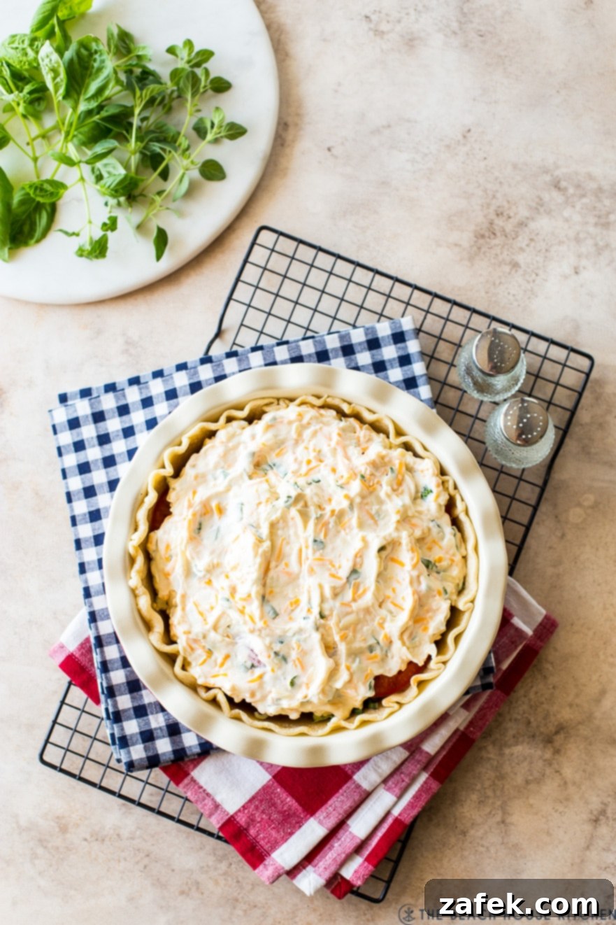 Rustic Summer Tomato Pie 6 Overhead photo of pre-baked tomato pie on two checked napkins on a wire rack