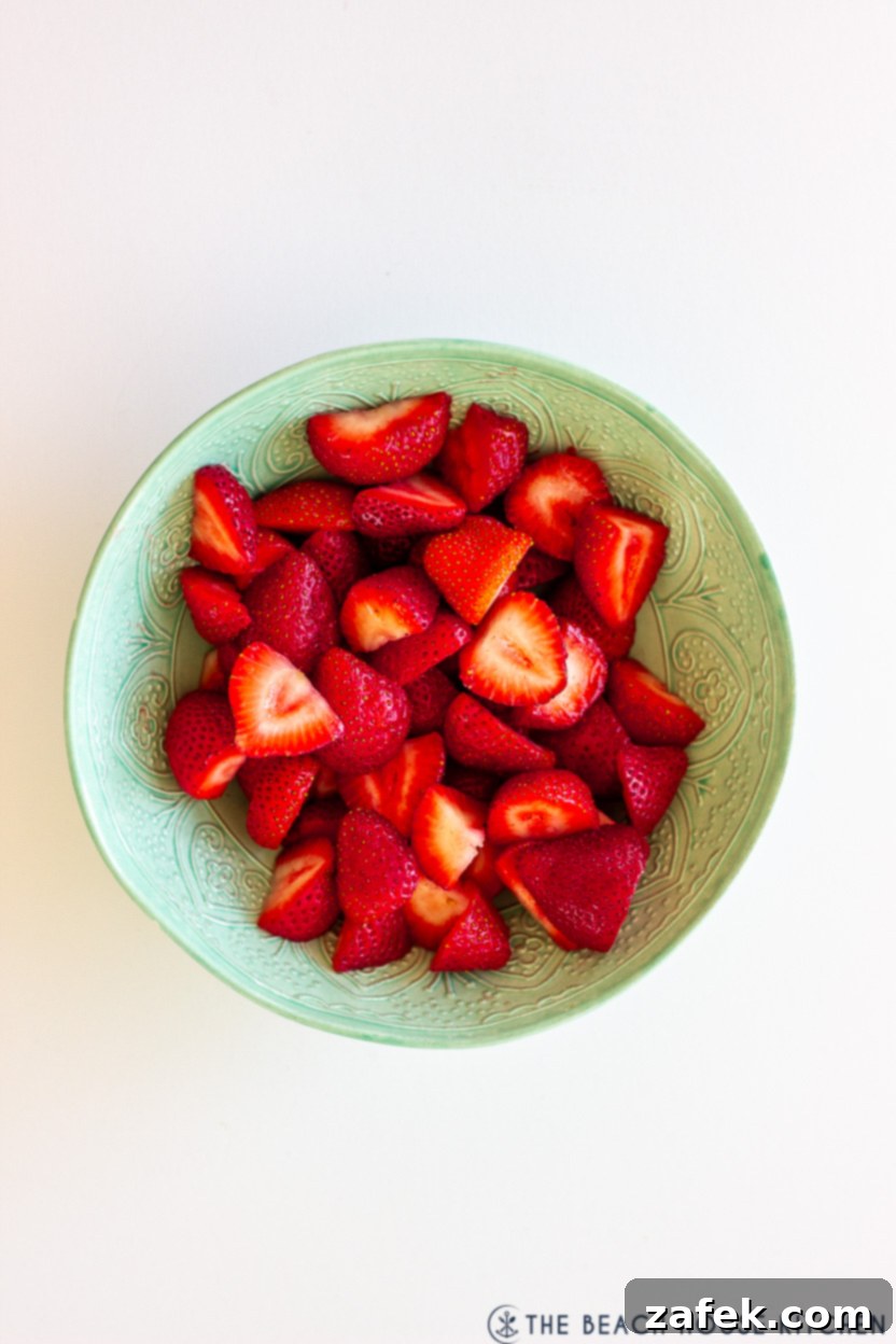 Strawberry Swirls for School Days 4 Overhead photo of a pale green bowl overflowing with fresh, vibrant sliced strawberries