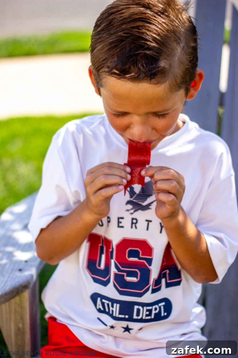 Strawberry Swirls for School Days 8 Young boy giving a thumbs up, enjoying a strawberry fruit roll-up