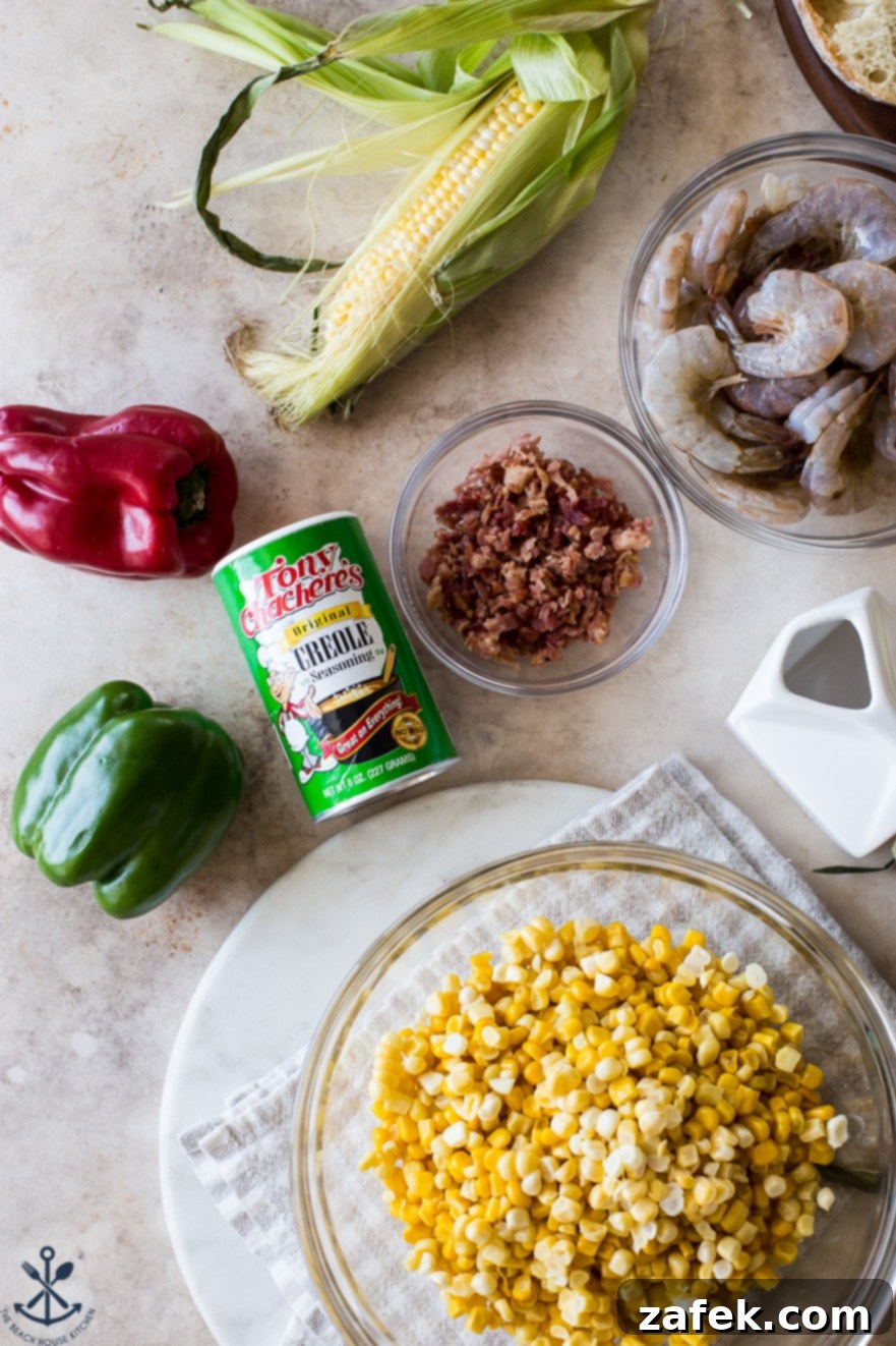 Overhead photo of ingredients for a corn dish with shrimp, neatly arranged in bowls alongside a can of creole seasoning.