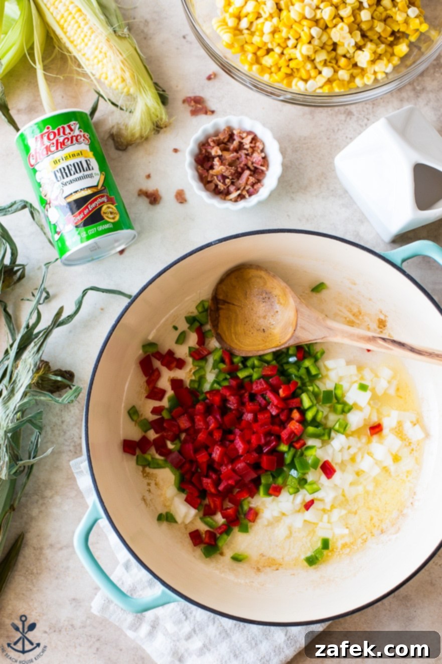 Overhead photo of a baking dish filled with finely chopped red and green bell peppers and onions, ready for cooking, with a wooden spoon.