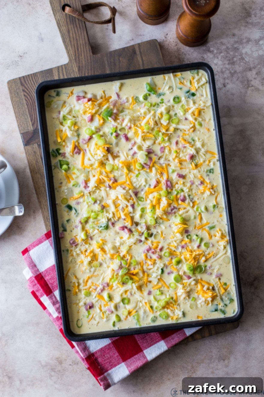 Overhead photo of a pre-baked sheet pan Denver omelette, golden and fluffy, ready for slicing