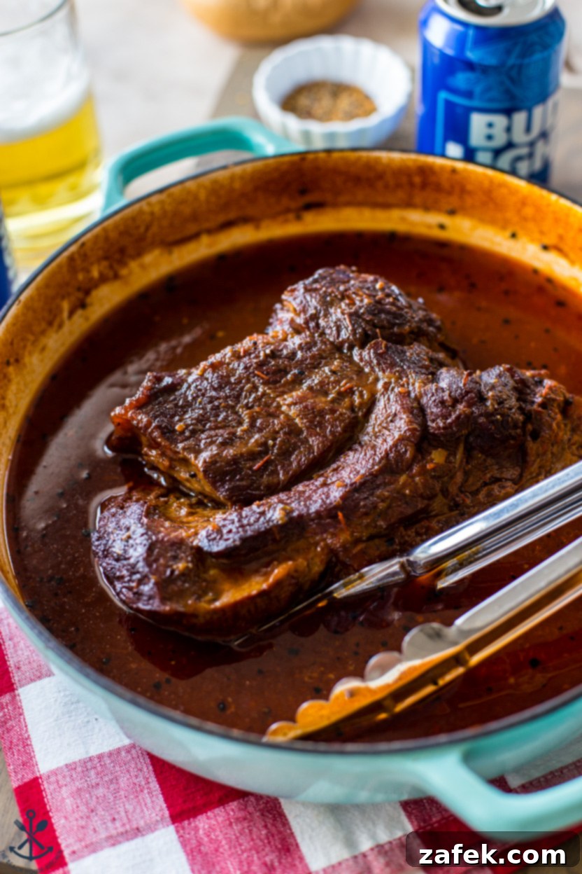 A cooked chuck roast in a skillet with gravy