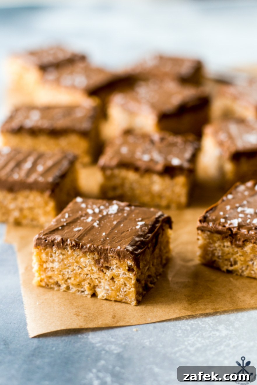 Sweet and Salty Peanut Butter Crunch Bars 2 Golden Scotcheroos on parchment paper, arranged beautifully on a rustic brown surface