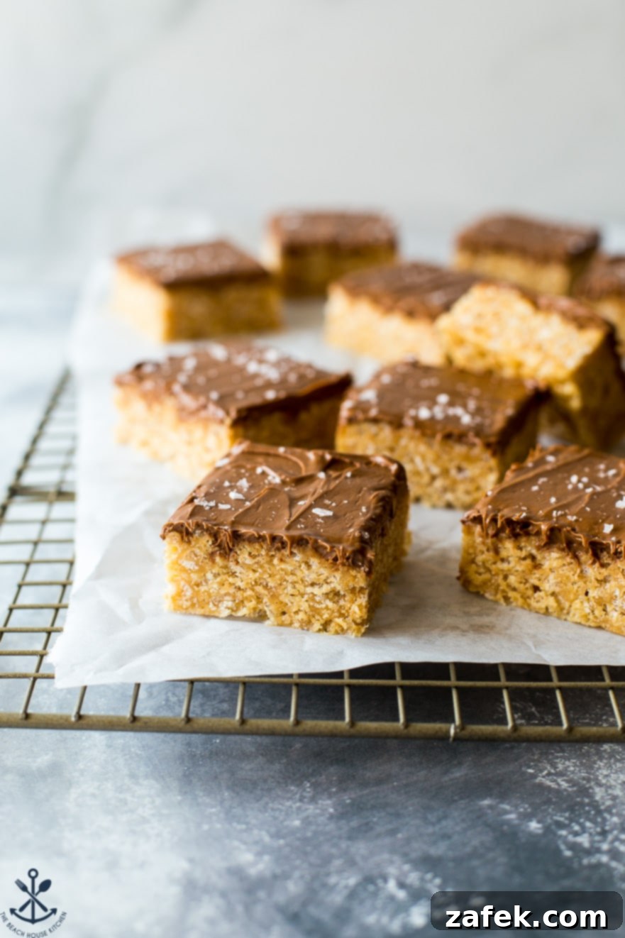 Sweet and Salty Peanut Butter Crunch Bars 7 Scotcheroos squares neatly stacked, some with a delicate sprinkle of sea salt, inviting a bite