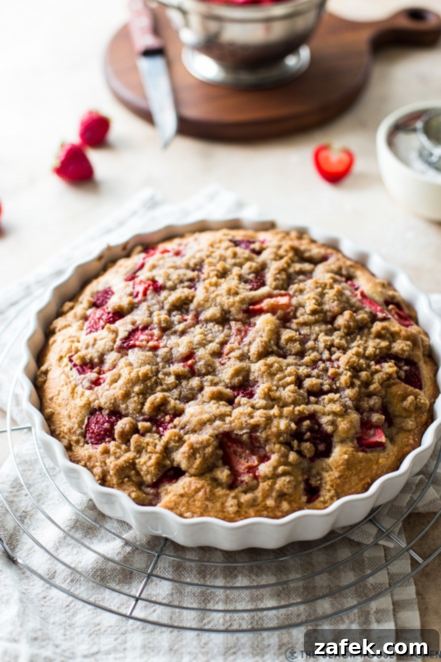 Sweet Strawberry Streusel 8 A warm Strawberry Buckle, straight from the oven, cooling on a round wire rack while still in its white baking dish, its inviting aroma filling the air.