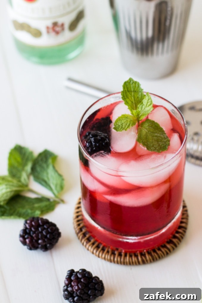 Midnight Bramble Refresher 5 Hand muddling fresh blackberries and mint with simple syrup in a cocktail shaker