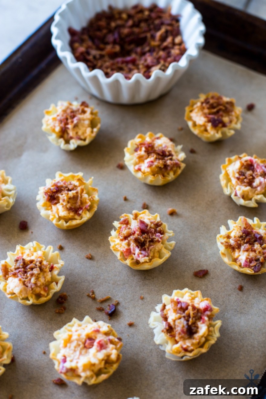 Bacon Pimento Cheese Poppers 4 Pre-baked Pimento Cheese Bites with bacon on a parchment lined baking sheet