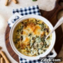 Ultimate Bacon Spinach Artichoke Dip 8 A perfectly baked, bubbly Spinach Artichoke Dip with Bacon in a white dish, ready to be served.