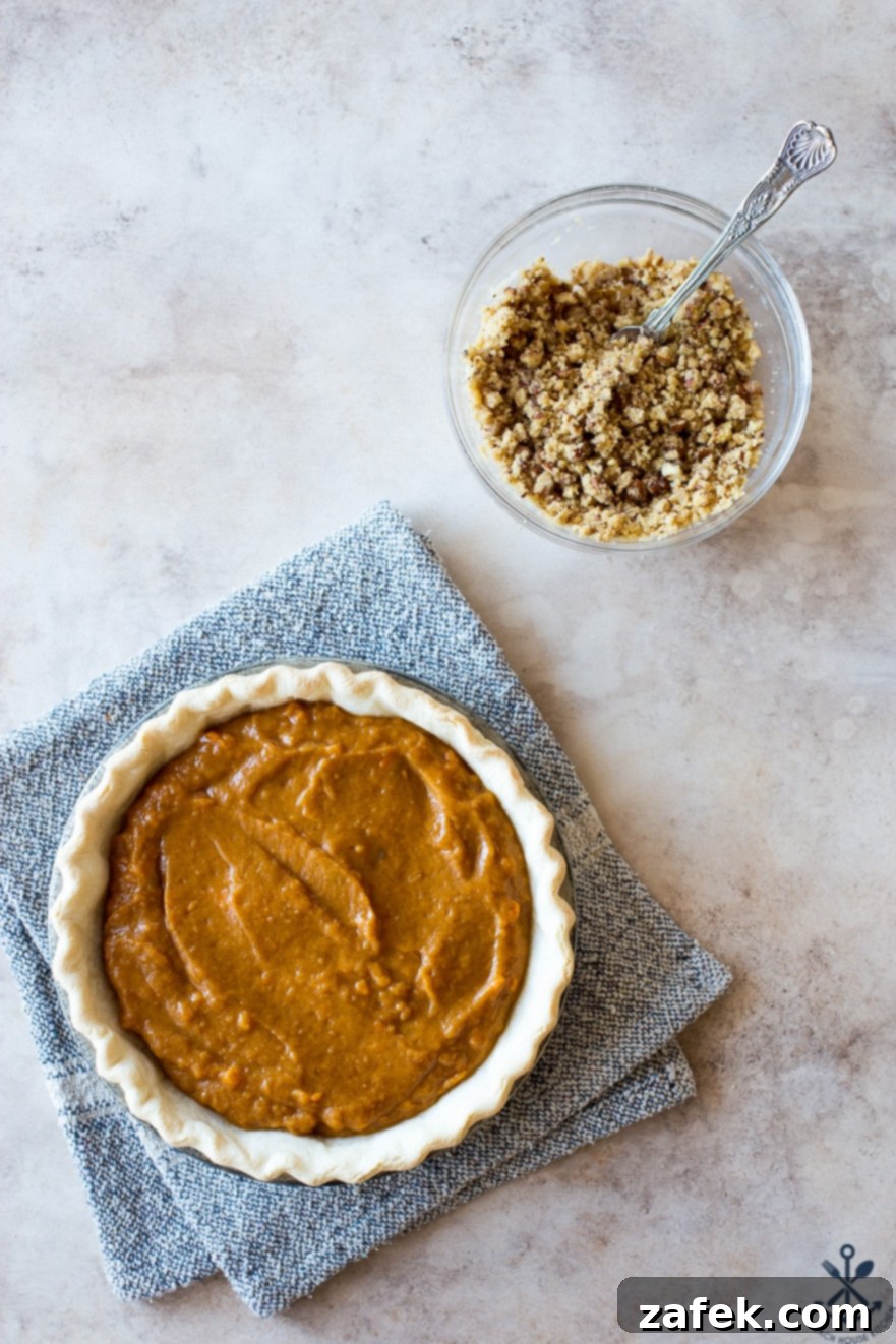 Sweet Potato Pie, Crowned with Pecans 7 Overhead photo of a prepared sweet potato pie, uncooked but ready for its pecan topping, with a separate bowl of topping ingredients waiting beside it.