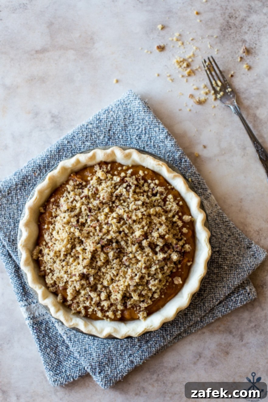 Sweet Potato Pie, Crowned with Pecans 8 Overhead photo of a baked sweet potato pie with its golden-brown pecan topping, cooling on a wire rack, steam gently rising.