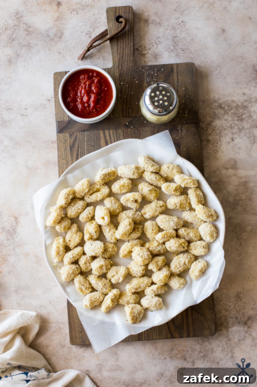 Crispy Gnocchi Delights 3 Overhead photo of pre-fried gnocchi bites neatly arranged on a parchment-lined plate, ready for cooking