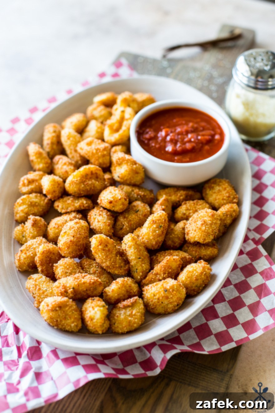 Crispy Gnocchi Delights 4 A beautifully arranged plate of golden deep-fried gnocchi bites with a small ceramic bowl of vibrant marinara sauce, ready to serve