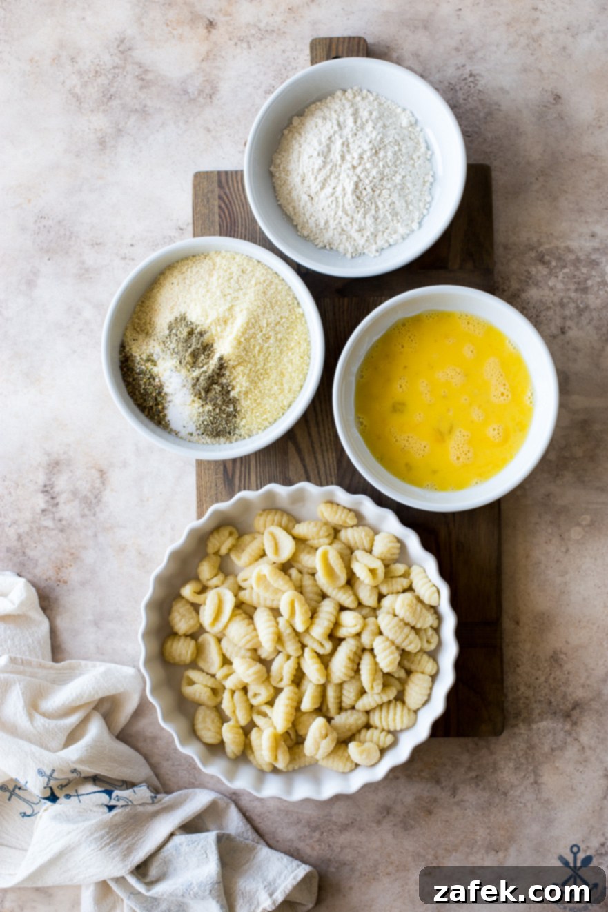 Crispy Gnocchi Delights 6 A culinary tableau featuring bowls of all-purpose flour, whisked eggs, uncooked potato gnocchi, and a mixture of Italian seasoned bread crumbs, Parmesan cheese, and various spices, arranged on a rustic wooden surface.