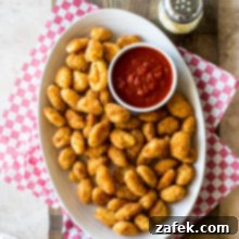 Crispy Gnocchi Delights 8 Overhead photo of an oval plate filled with toasted gnocchi and a small bowl of marinara sauce, ready to be enjoyed.