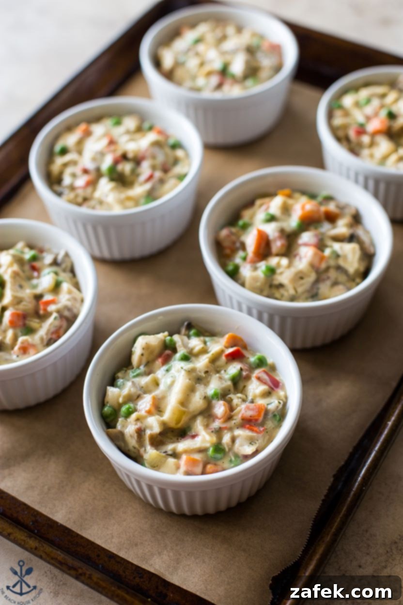 Flaky Puff Chicken Pot Pie 3 Six individual ramekins filled with rich chicken and vegetable mixture, before being topped with puff pastry and baked. The inviting golden filling hints at the deliciousness to come.