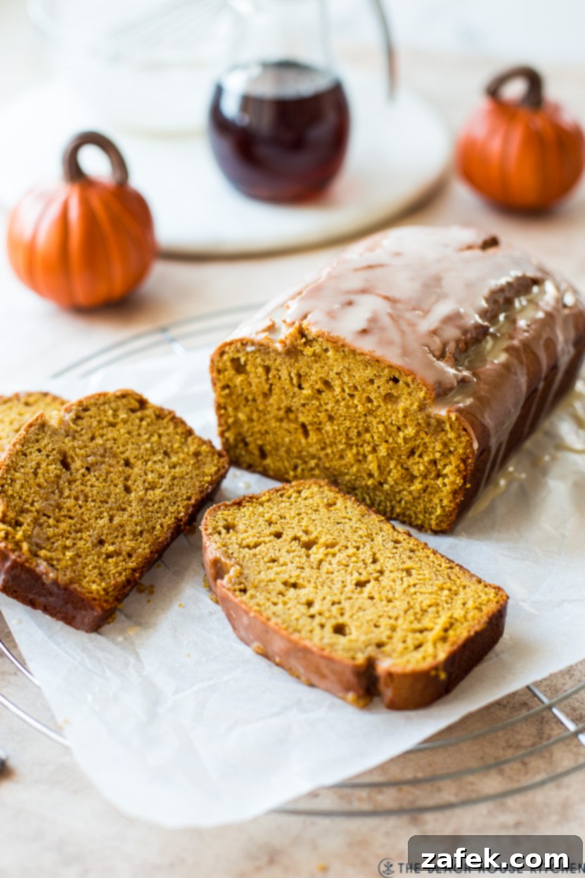 Cozy Maple Kissed Pumpkin Bread 2 A beautifully baked loaf of maple glazed pumpkin bread cooling on a round wire rack, ready to be sliced and enjoyed.