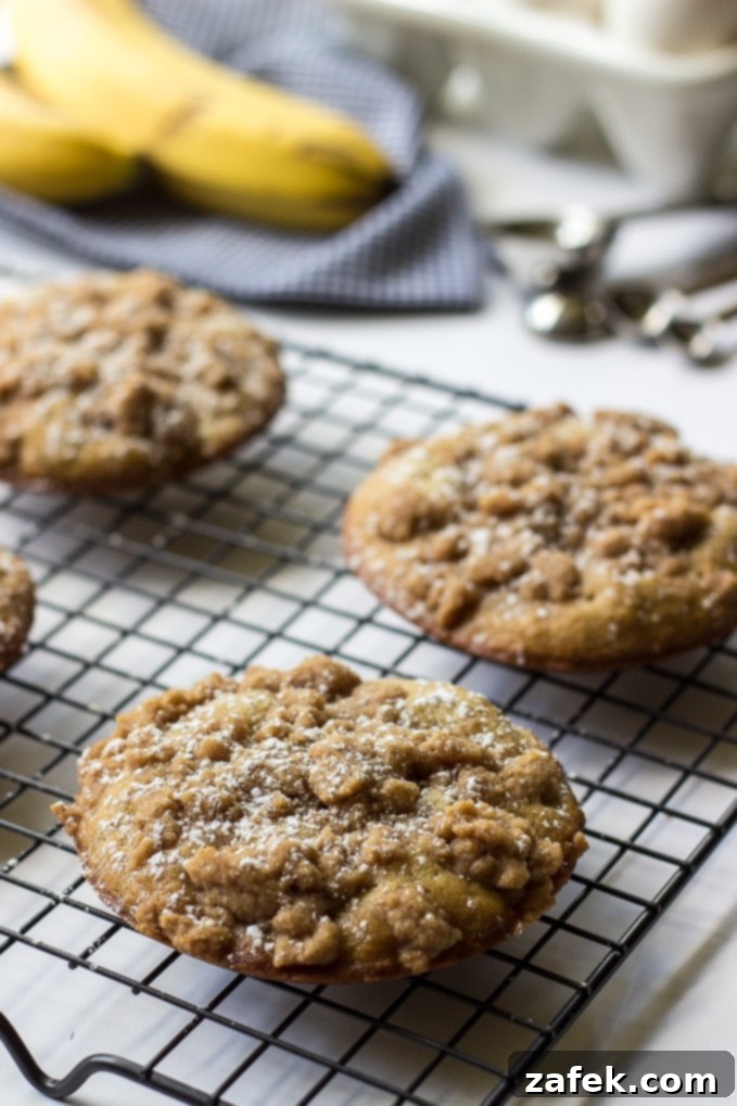 Banana Crumb Cake Muffin Tops - Stacked muffin tops on a rustic wooden board.