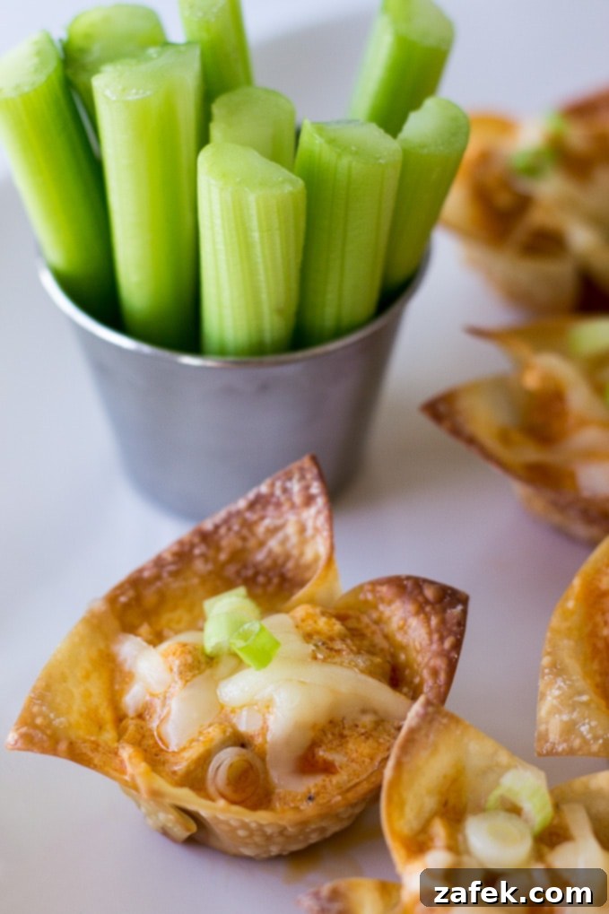 Close-up of a single Buffalo Chicken Wonton Cup, showcasing the crispy wrapper and creamy filling.