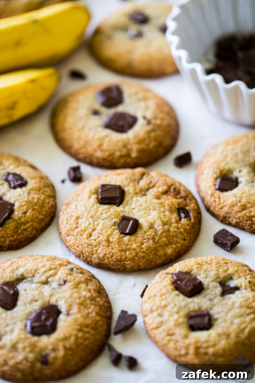 Decadent Bananas Foster Chocolate Chunk Cookies 2 Delicious Bananas Foster Chocolate Chunk Cookies arranged with fresh bananas and a bowl of chocolate chips, perfect for holiday baking