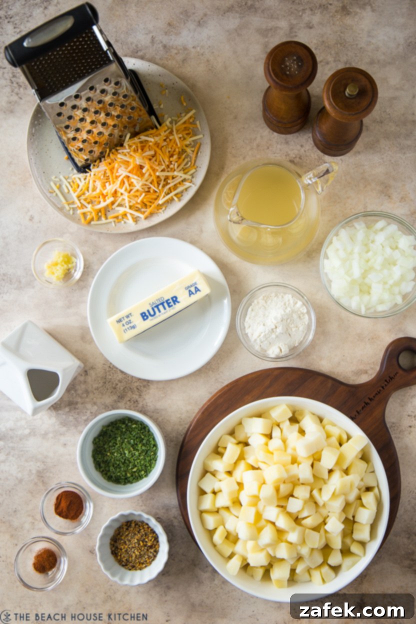 Overhead photo displaying all raw ingredients for cheesy potatoes, including a bag of cubed potatoes, butter, onion, garlic, spices, broth, cream, cheddar cheese, and chives.