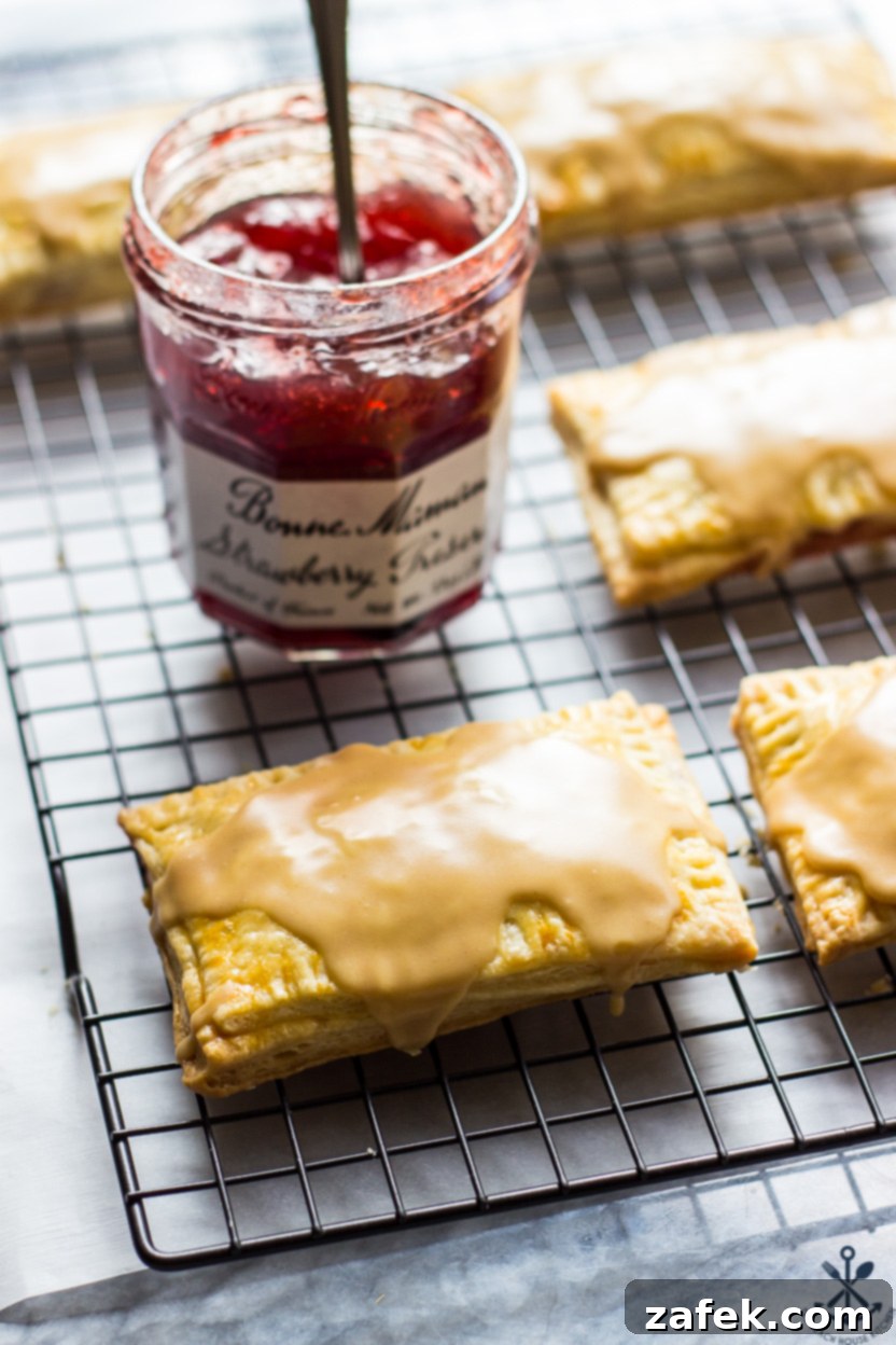 Peanut butter glazed pop tarts on a wire rack with a jar of preserves