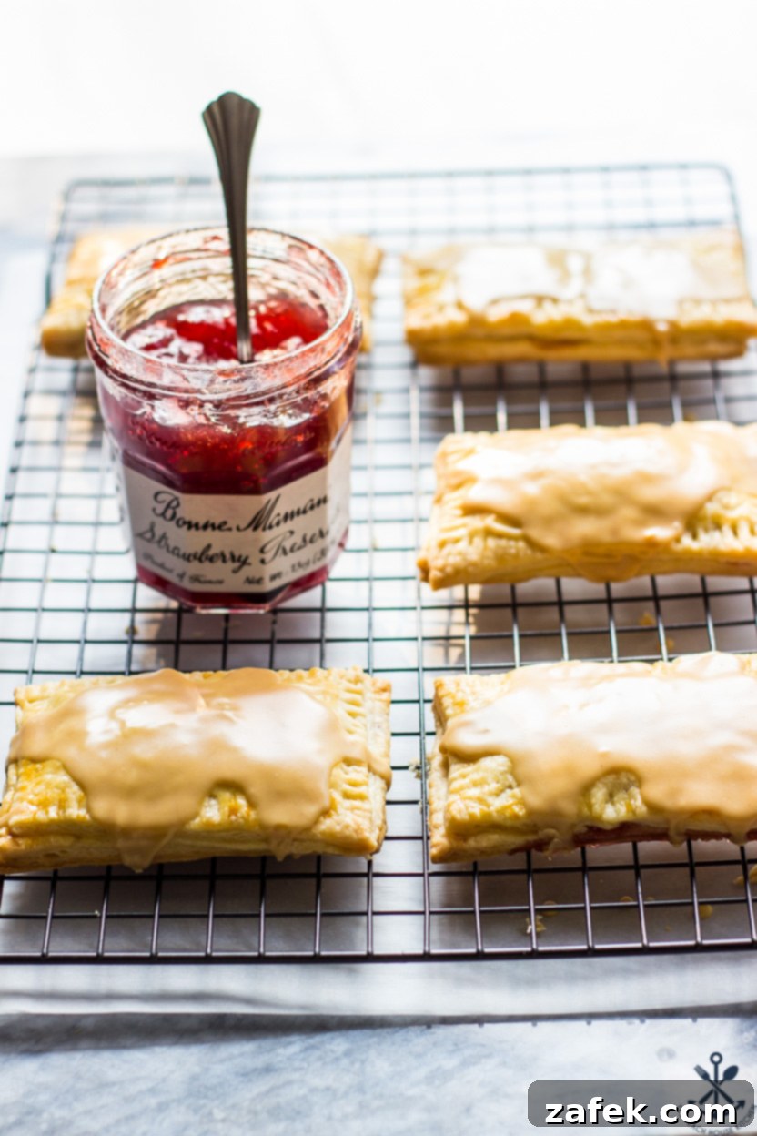 Homemade Peanut Butter and Jelly Pop-Tarts on a wire rack with a jar of preserves