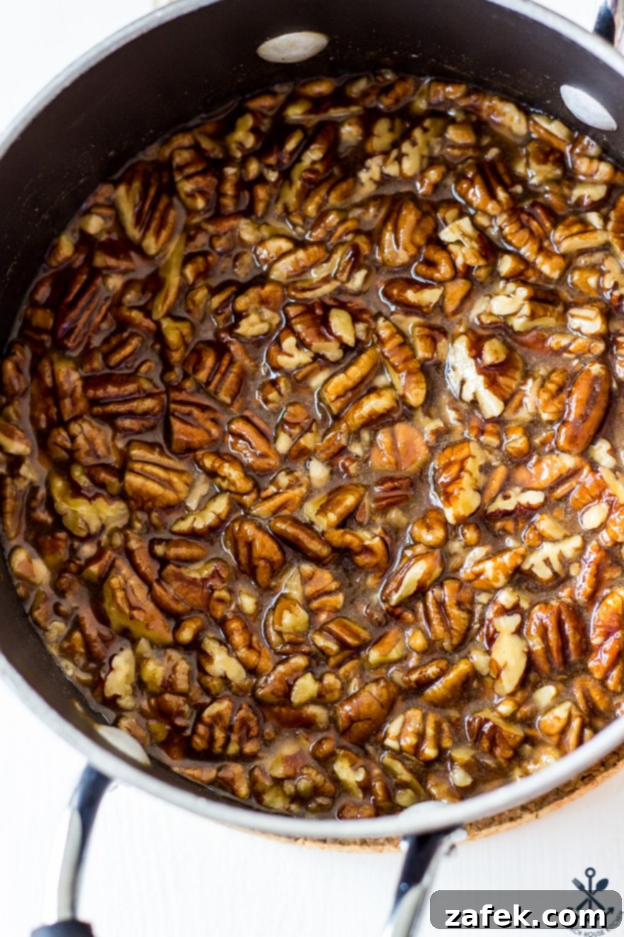 Decadent Maple Pecan Bars Adorned with Chocolate 5 Overhead photo of raw pecan halves being lightly toasted in a saucepan, a key step for enhancing their flavor in the maple pecan topping