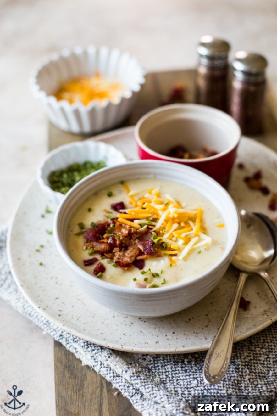 Bacon Cheddar Baked Potato Soup 3 A bowl of soup on a plate with a spoon