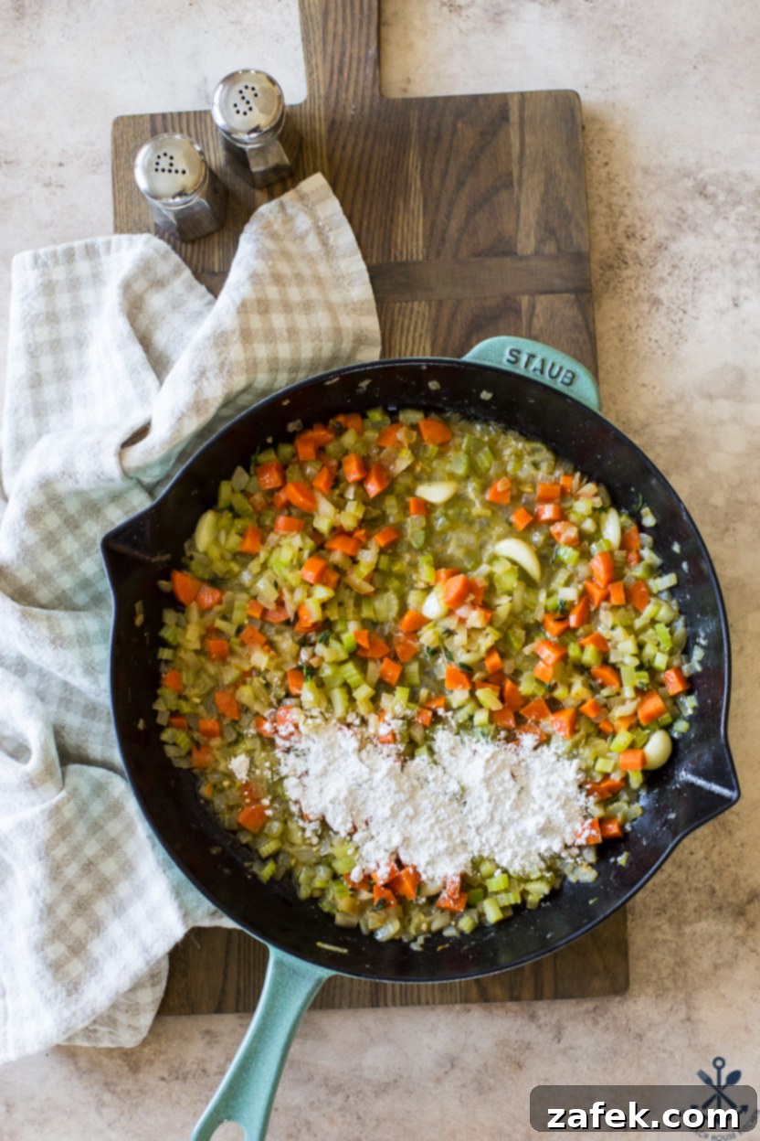 Garlic Chicken Delight 7 Overhead photo of a skillet of cooked vegetables topped with all-purpose flour, forming the roux