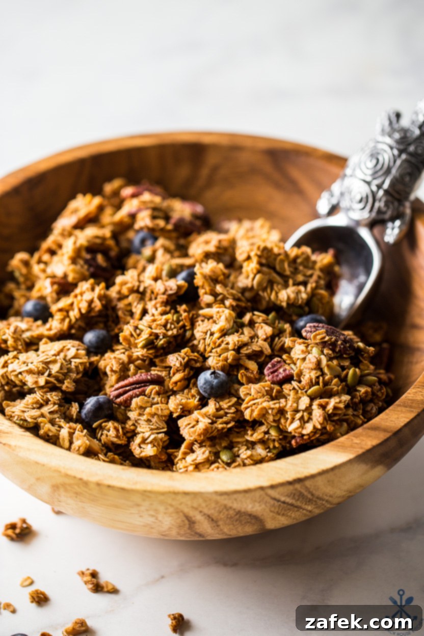 Sunshine Lemon Berry Crunch 3 Up close photo of a wooden bowl of granola with blueberries