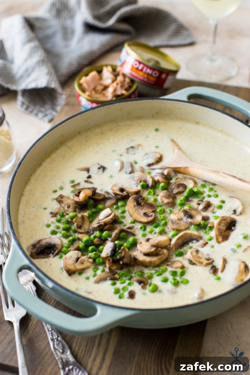 Savory Tuna Pasta with Earthy Mushrooms and Sweet Peas 5 A skillet filled with a cream sauce with mushrooms and peas