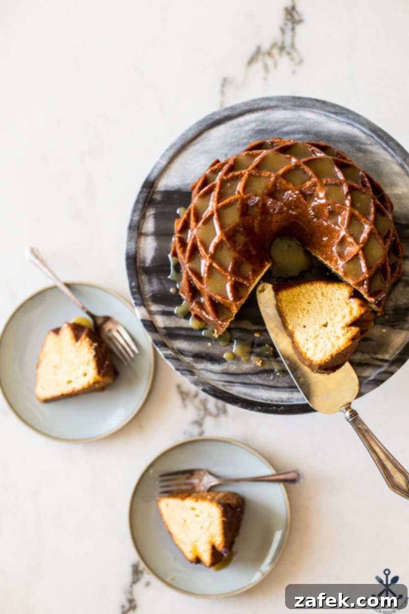Overhead photo of a brown sugar bundt cake on a cake stand, accompanied by two plates featuring slices of the delicious cake, inviting enjoyment.