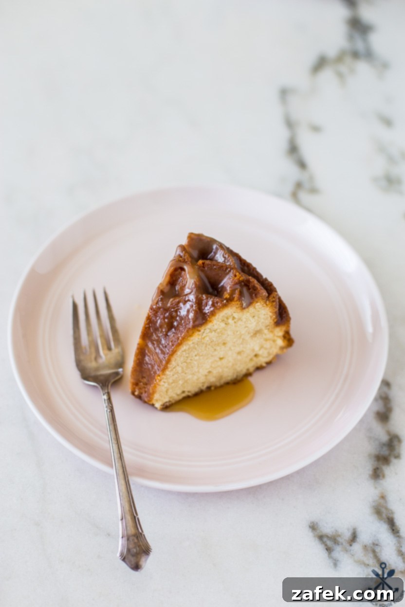 A perfectly sliced piece of brown sugar bundt cake, served on a delicate pink plate, revealing its moist interior and ready for enjoyment.
