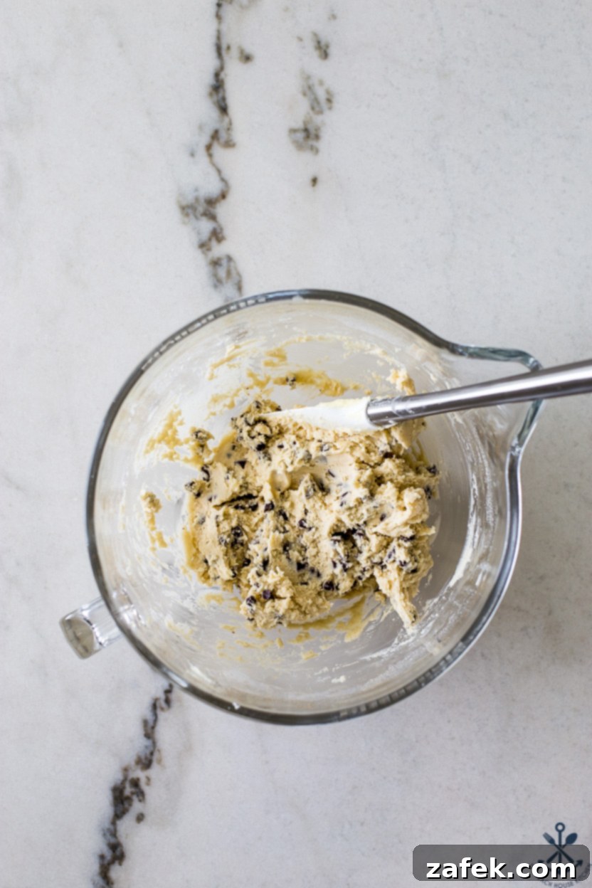 Tropical Chocolate Chip Cookie Logs 5 Overhead photo of a glass bowl filled with prepared coconut chocolate chip cookie dough, ready for shaping and chilling.