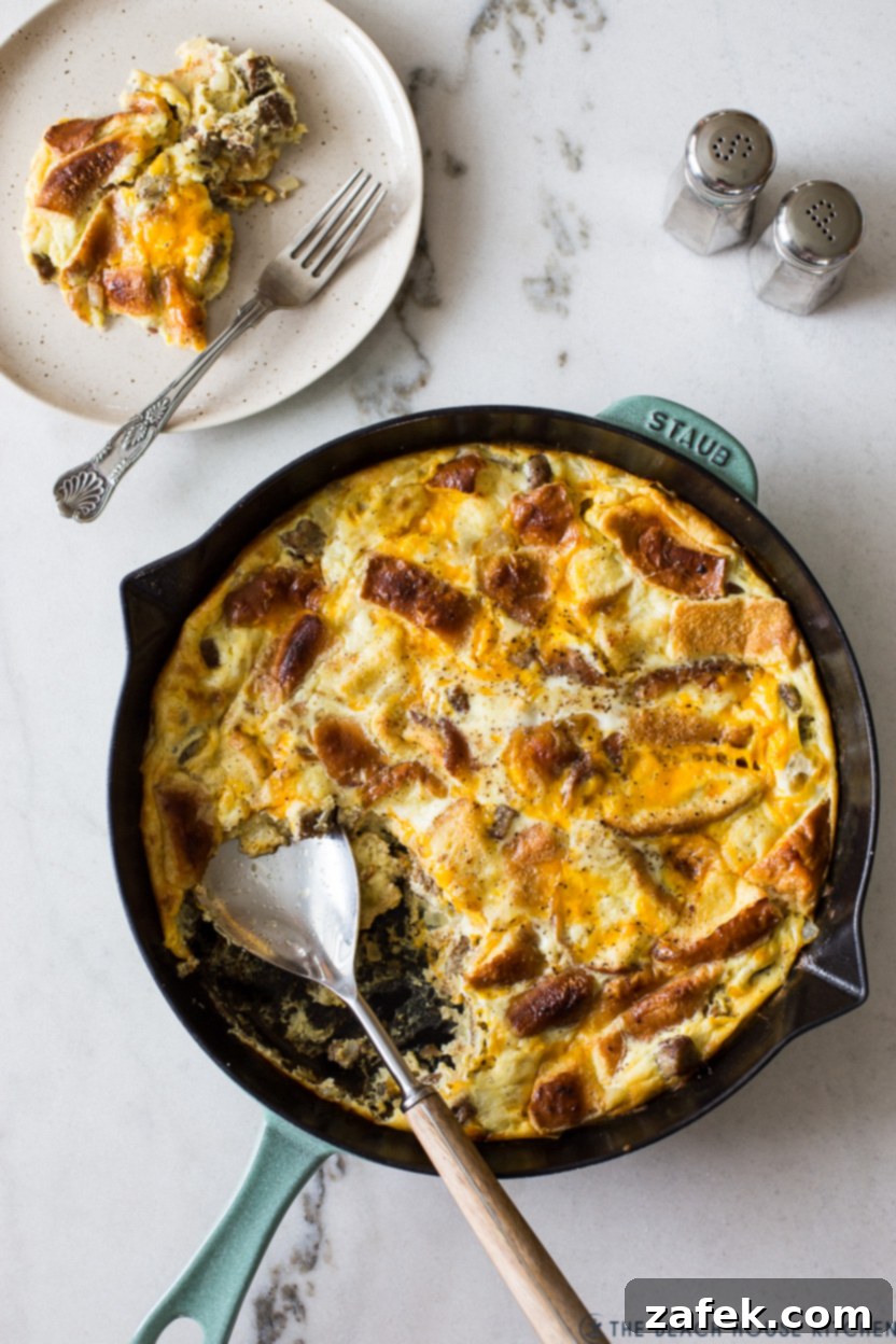 Decadent Skillet Brioche Sausage Egg Strata 3 Close-up overhead view of the golden, bubbly Skillet Brioche Egg and Sausage Strata in an oven-safe pan