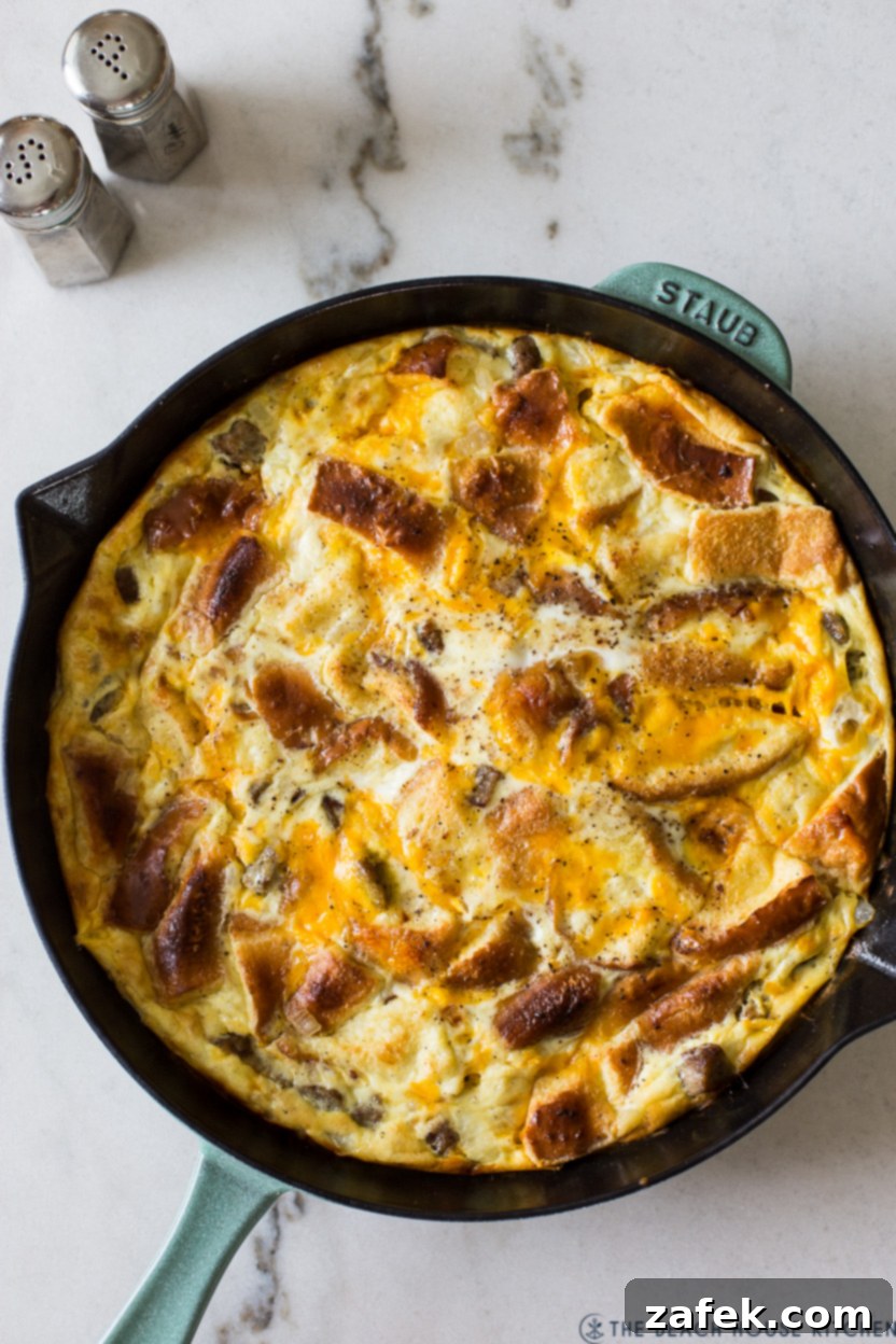 Decadent Skillet Brioche Sausage Egg Strata 5 Close-up shot of a single serving of Skillet Brioche Egg and Sausage Strata, showing the tender brioche and melted cheese