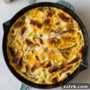 Decadent Skillet Brioche Sausage Egg Strata 6 Overhead photo of an egg strata in a skillet, garnished and ready to serve