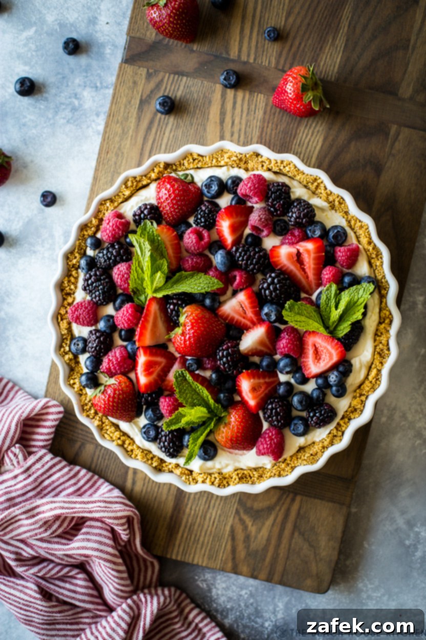 Vibrant Berry Tart 3 Overhead photo of a freshly made berry tart, beautifully arranged with mixed berries on a rustic wooden board