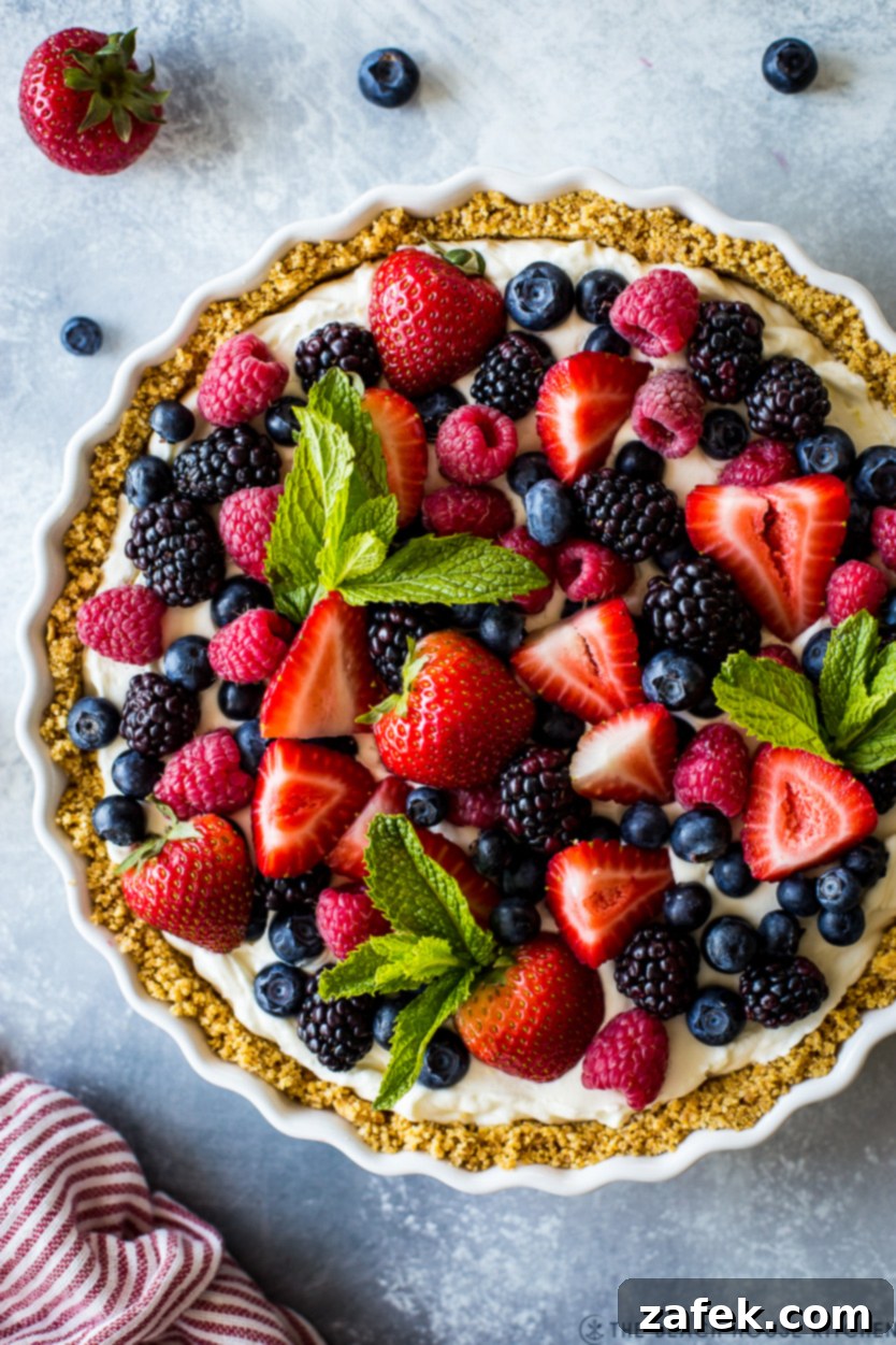 Vibrant Berry Tart 9 Up close overhead photo of a tart lavishly topped with an assortment of fresh berries, showing its irresistible texture